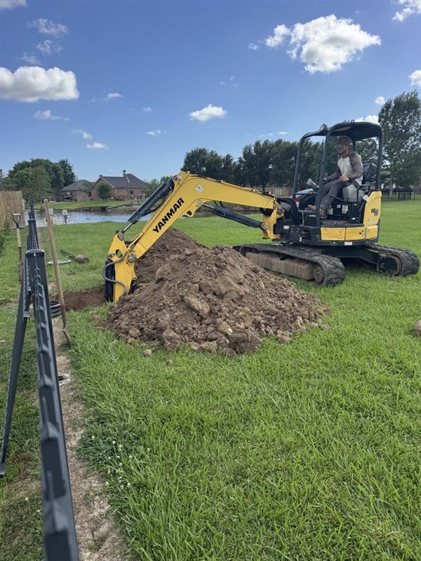 Yanmar excavator working beside a fence on a grassy property